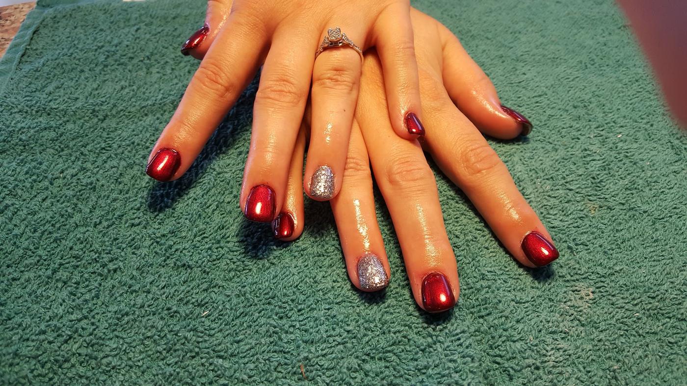 Finished deep red gel nails with a glitter accent nail